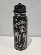 Black 32oz hydro water bottle with full engraved  designs on a silver background