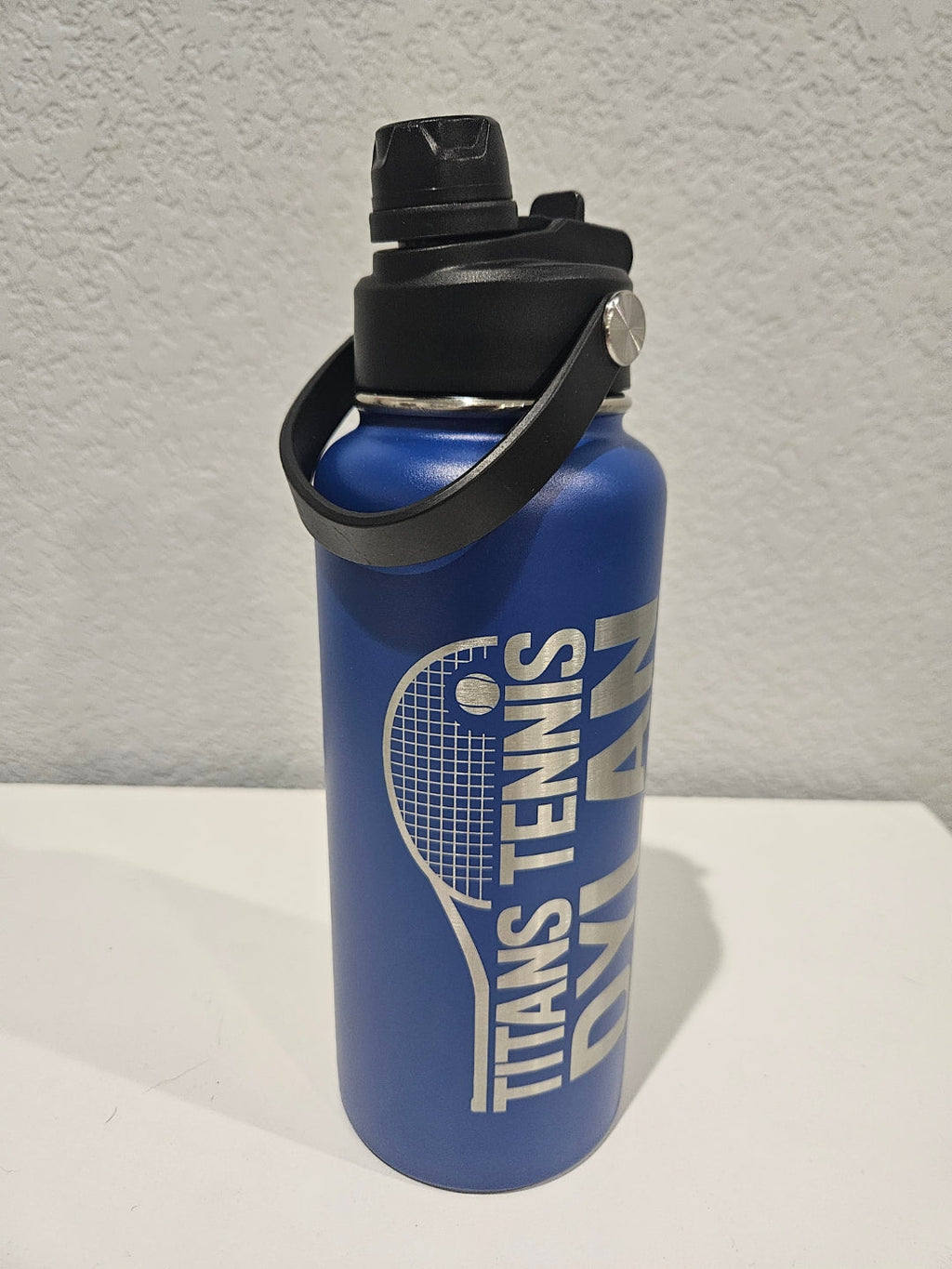 32 oz Blue hydro water bottle with black lid featuring single engraved, logo 