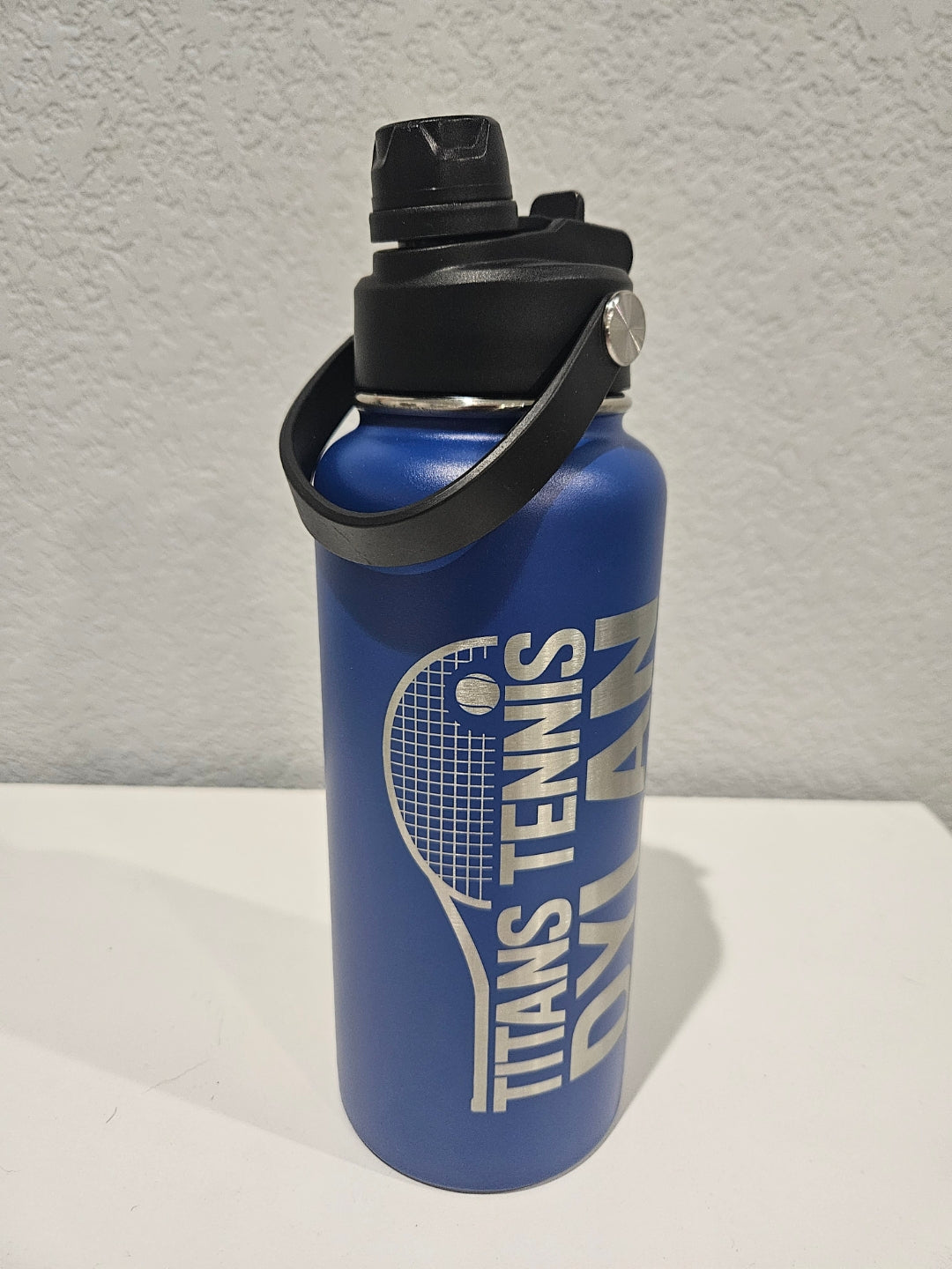 32 oz Blue hydro water bottle with black lid featuring single engraved, logo 