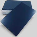 A stack of black metal rectangular cards with rounded corners, with one card leaning in front on a light gray background.