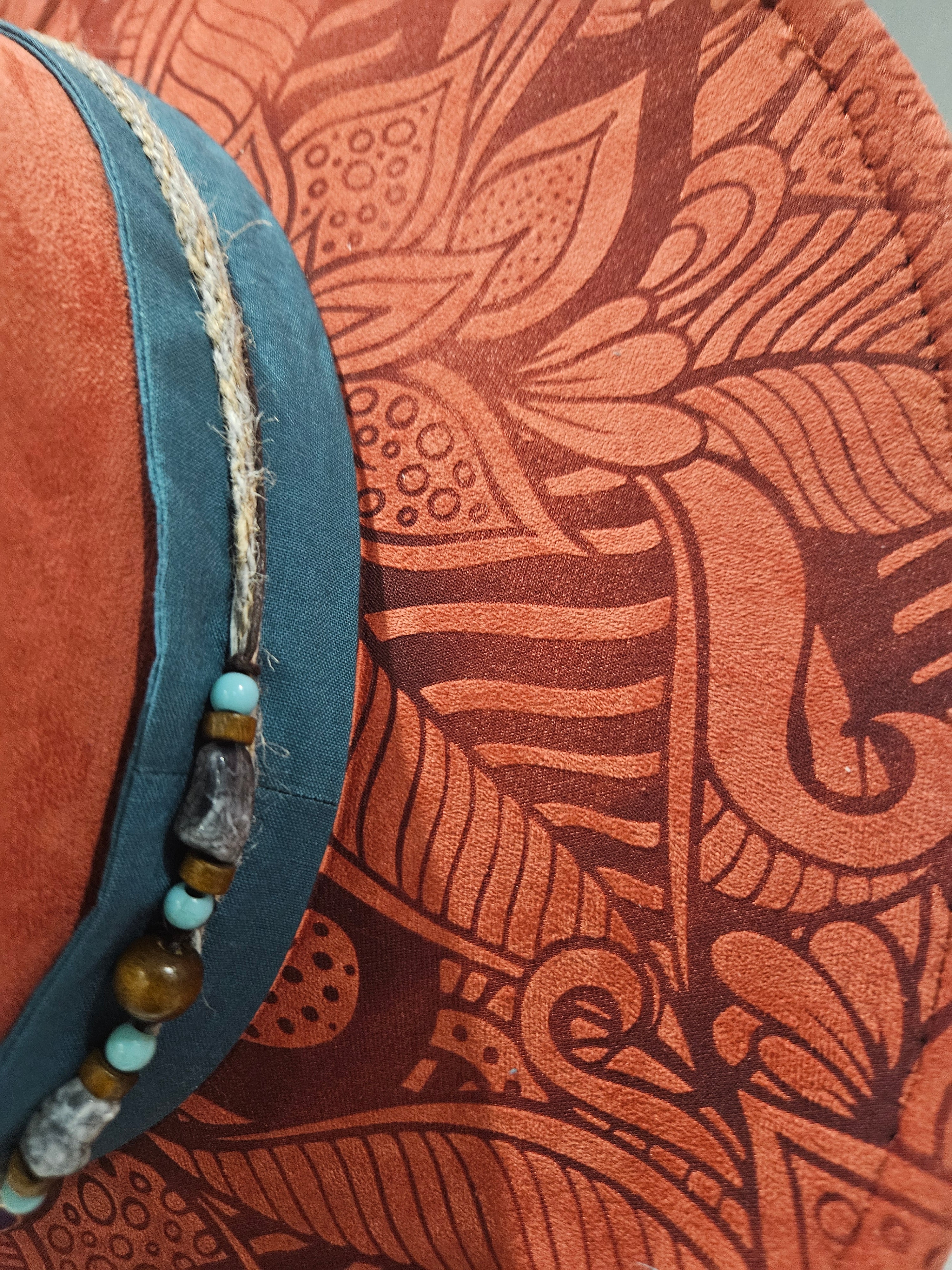 Close up detail of left side laser engraved organic geometric design on rusty red wide brim hat