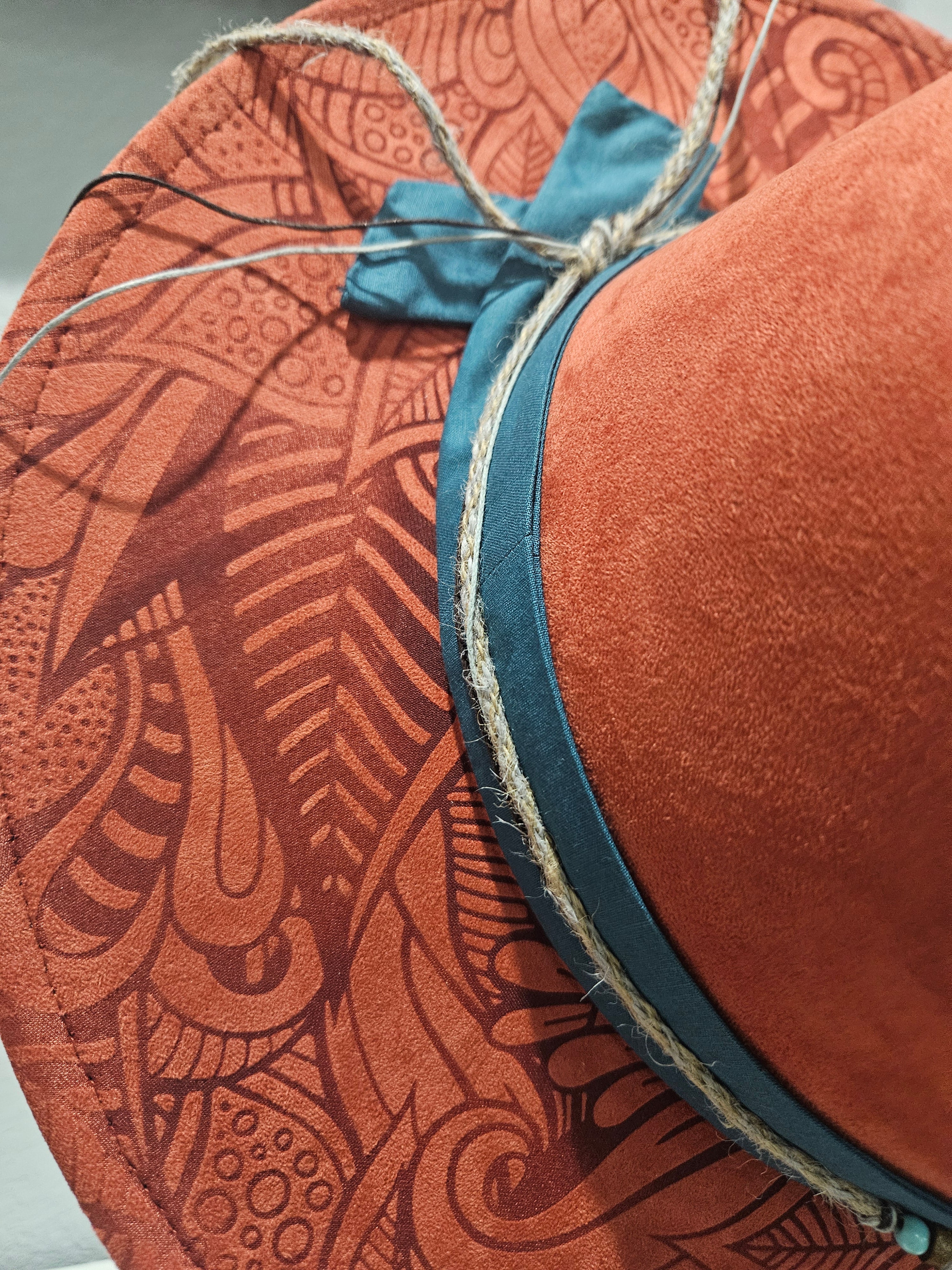 Close up detail of right side laser engraved organic geometric design on rusty red wide brim hat